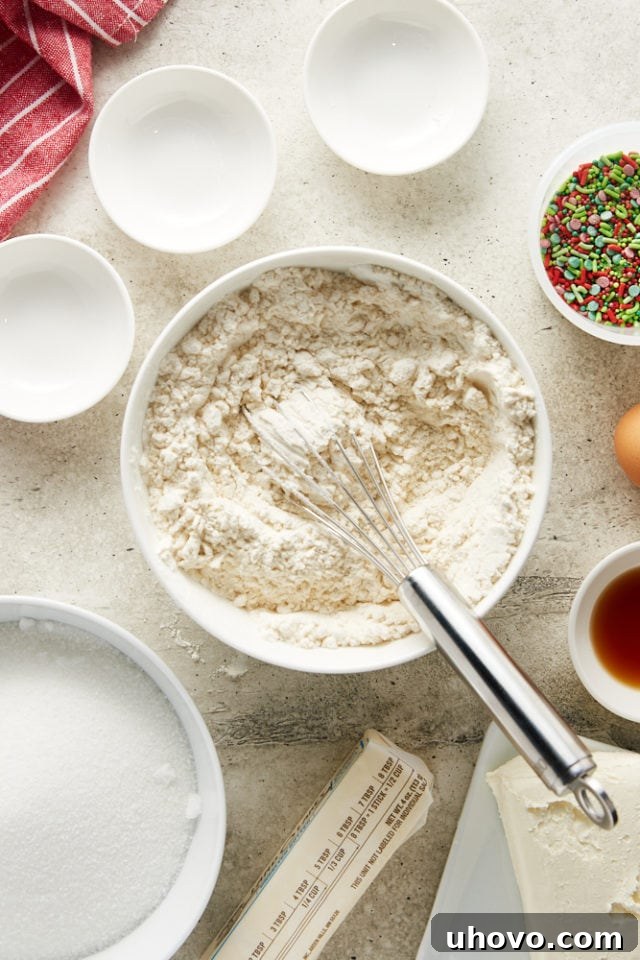 Overhead view of mixed dry ingredients for sugar cookies after being whisked together in a white mixing bowl.