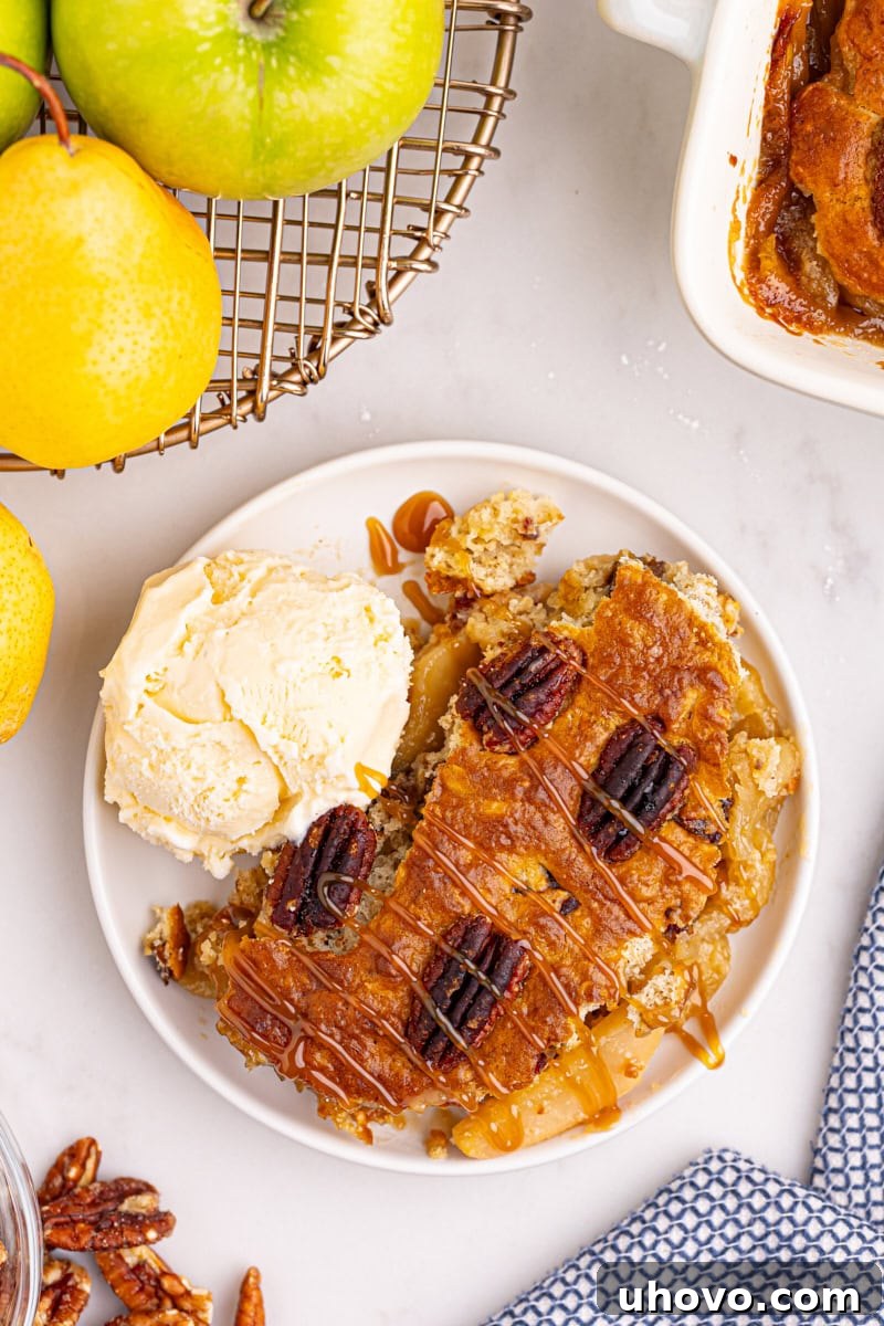 A delectable serving of caramel apple pear cobbler on a pristine white plate, crowned with a melting scoop of vanilla ice cream, creating a perfect hot and cold contrast.