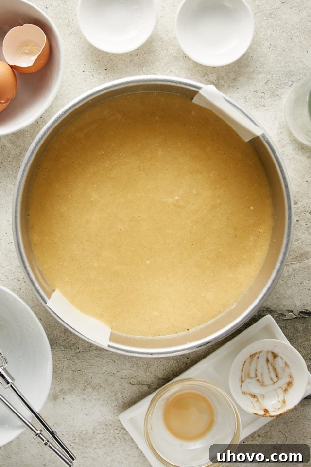 Irish Cream Cake batter expertly spread into a parchment-lined cake pan, ready for the oven.