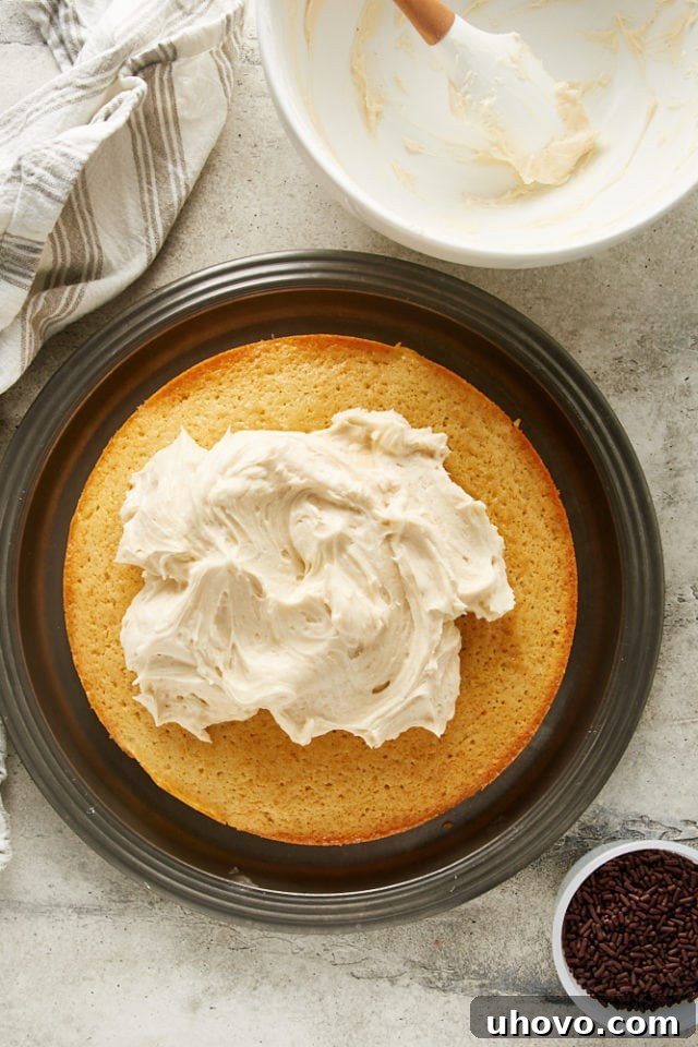 A generous layer of Irish Cream frosting being spread over the cooled cake, transforming it into a luxurious dessert.