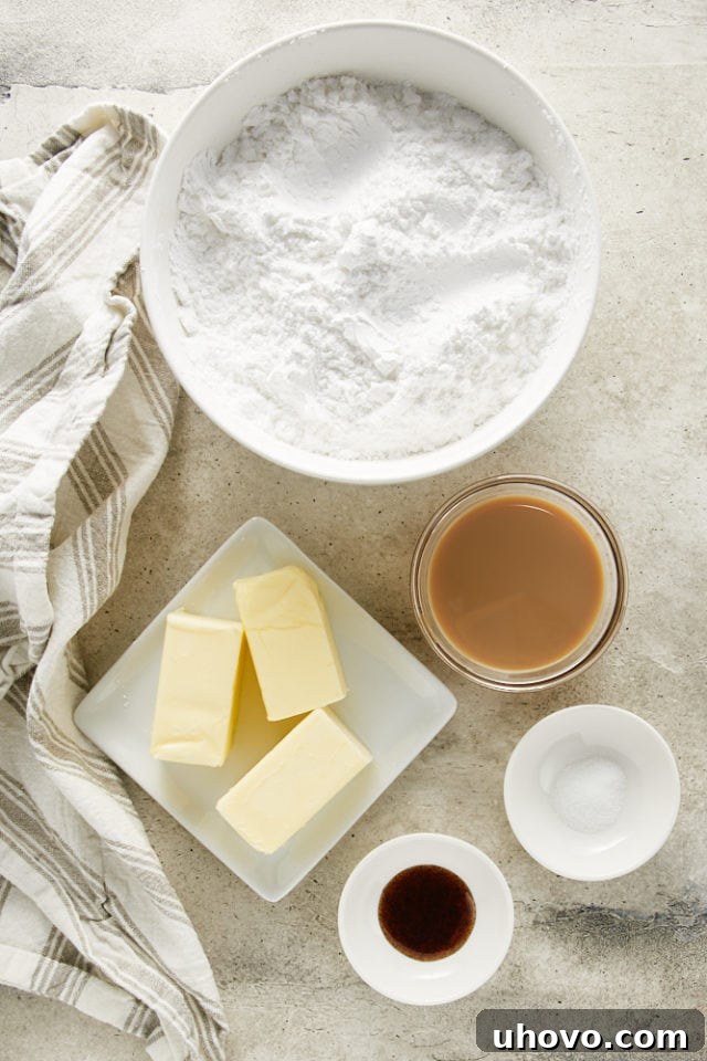A collection of ingredients laid out for making Irish Cream Frosting, including powdered sugar, butter, and Irish cream liqueur.