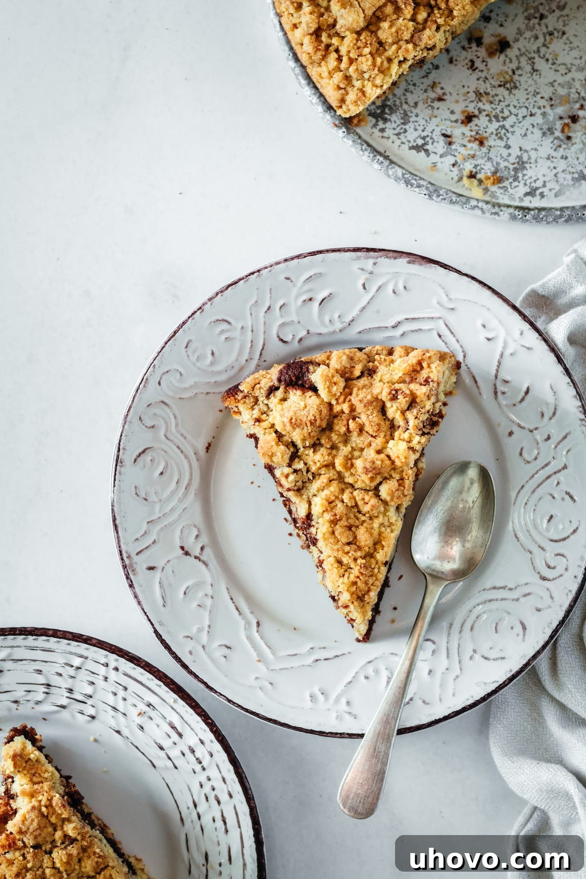 Overhead view of two slices of Chocolate Swirl Coffee Cake on a plate with a spoon, showing the beautiful marbling and crumb.