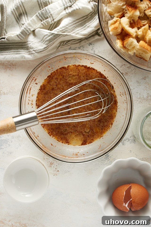 Pouring the milk mixture over the bread mixture for Cinnamon Almond Bread Pudding for Two.