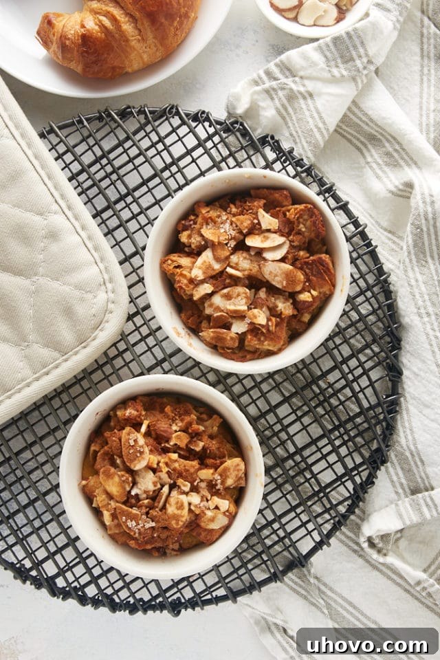 Overhead view of freshly baked Cinnamon Almond Bread Pudding for Two cooling on a wire rack, with golden brown tops.
