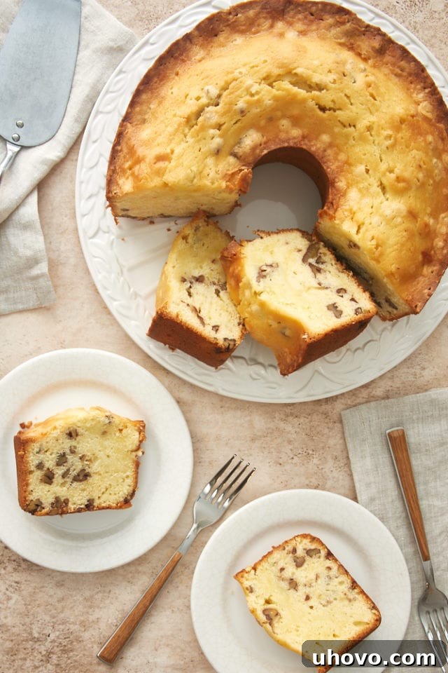 Overhead view of several slices of cream cheese pound cake on white plates, with the remaining cake on a white cake plate, illustrating portion control and presentation.