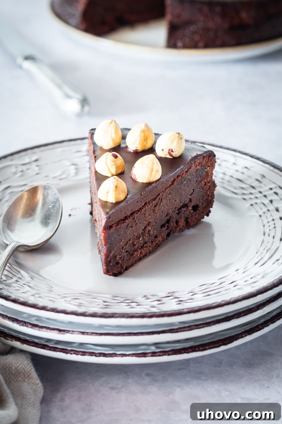 slice of chocolate hazelnut cake on a stack of white plates