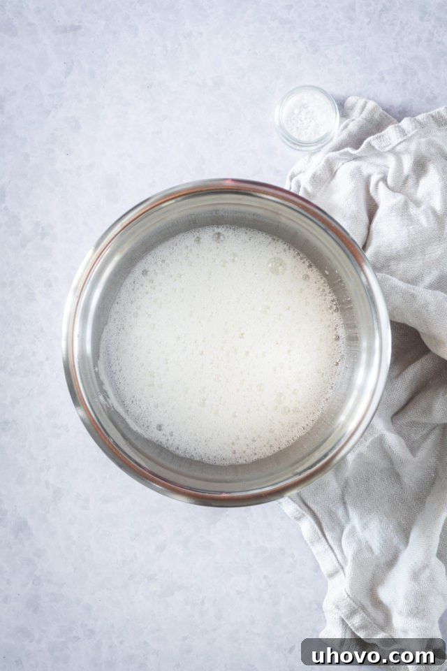 egg whites in a mixing bowl beaten to a foam