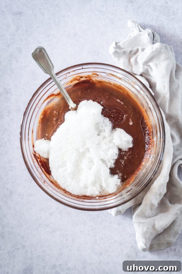 bowl of chocoalte cake batter with egg white foam on top