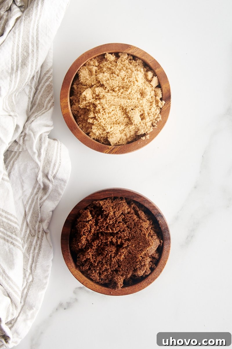 overhead view of light and dark muscovado sugars in small wooden bowls