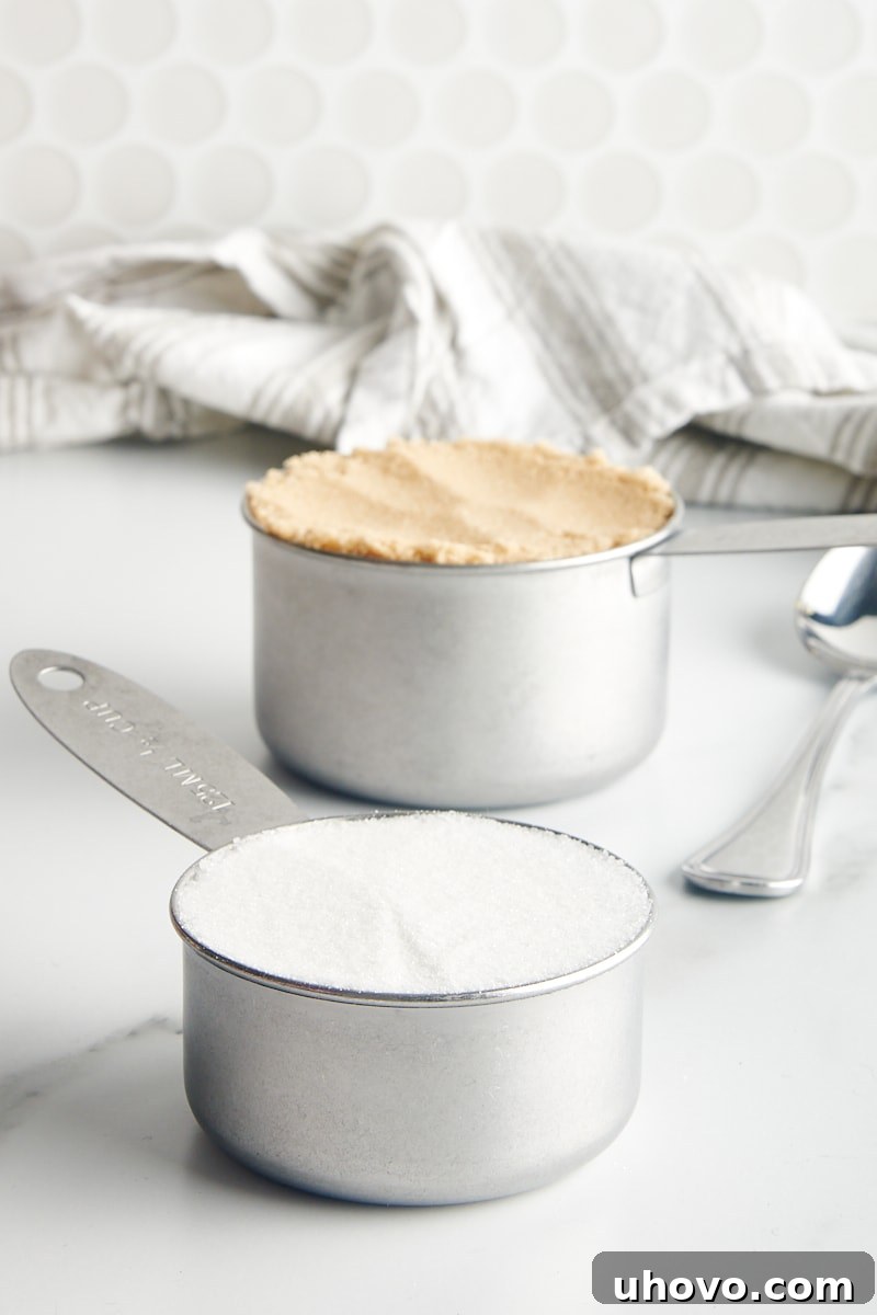 granulated sugar and brown sugar in metal measuring cups