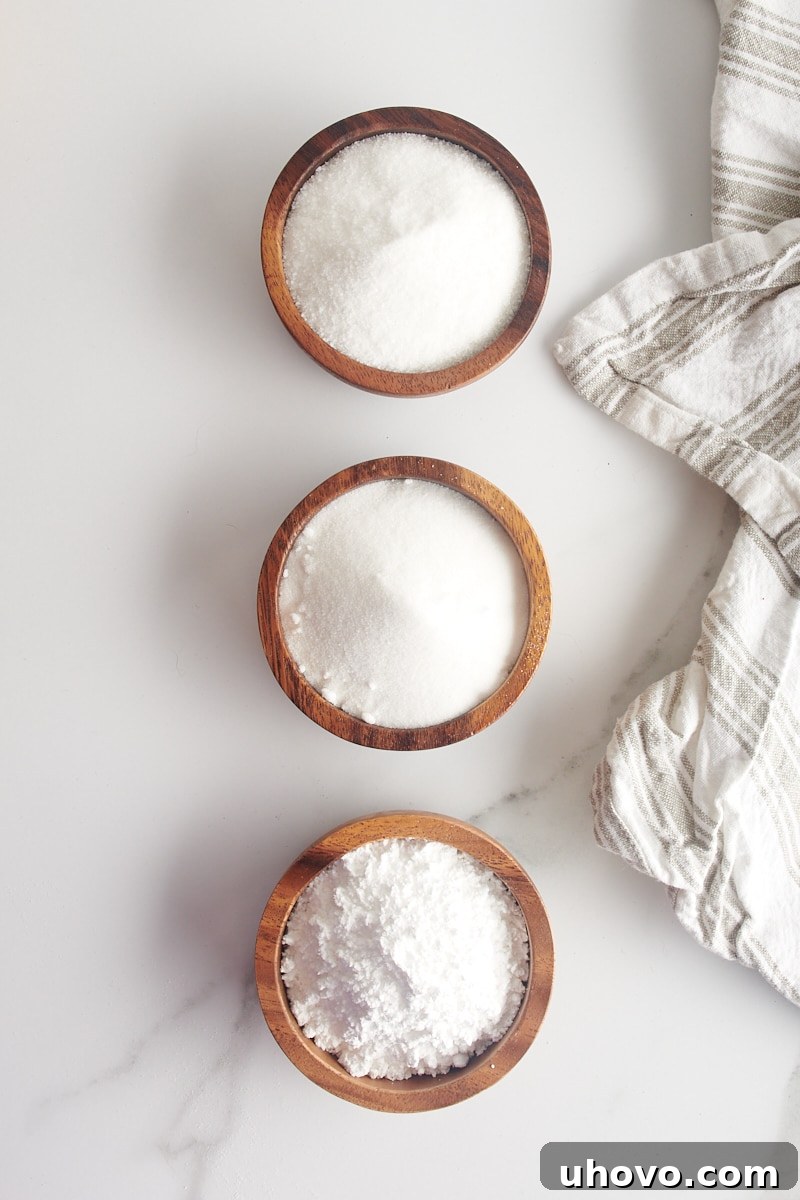 overhead view of granulated sugar, superfine sugar, and confectioners' sugar in wooden bowls