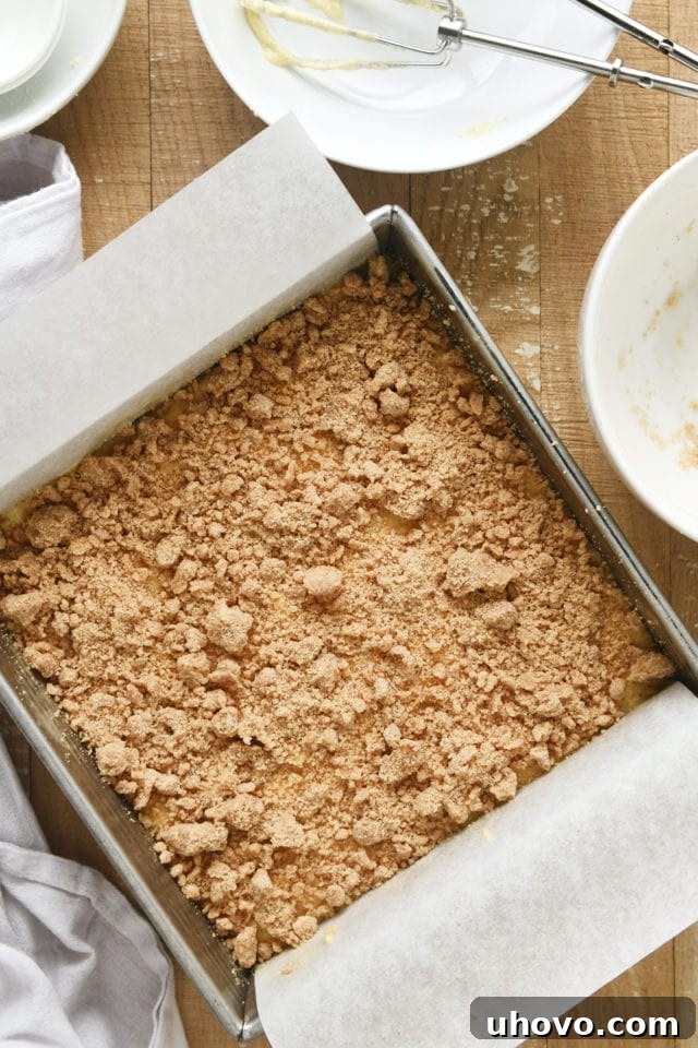 Overhead view of the crumb topping generously added to the Almond Crumb Cake batter in a square baking pan.