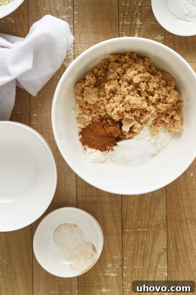 Overhead view of cinnamon crumb topping ingredients in a white mixing bowl, ready for mixing.