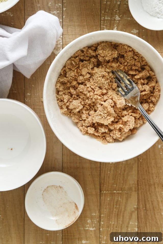 Overhead view of the finished crumb topping mixture in a white mixing bowl, perfectly crumbly.