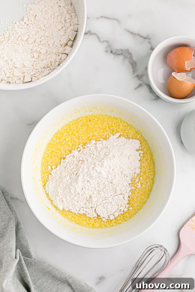 Overhead view of dry ingredients added to bowl of wet ingredients