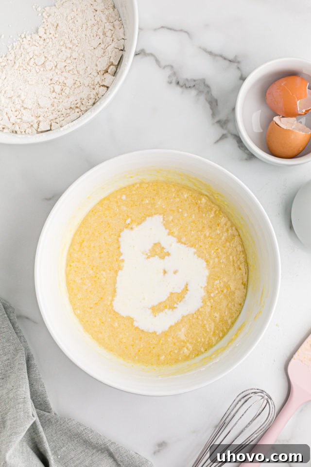 Overhead view of dry ingredients added to bowl of wet ingredients