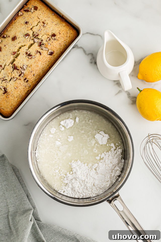 Overhead view of lemon bread in pan and glaze ingredients in saucepan