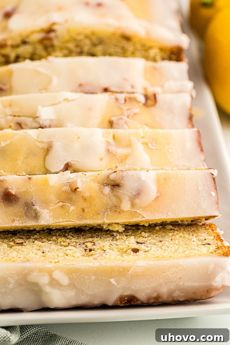 Sliced glazed lemon bread on white serving platter