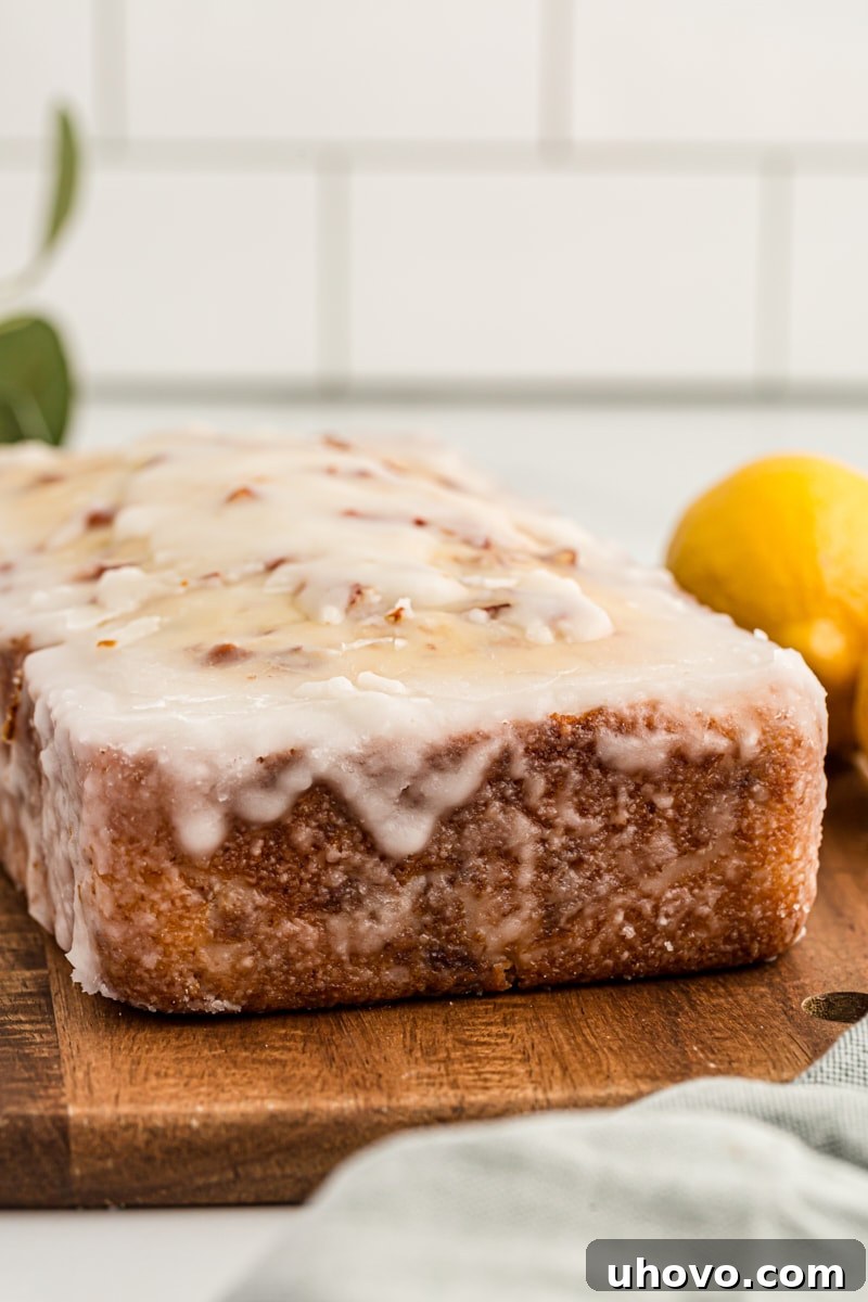 Glazed lemon bread on wood cutting board