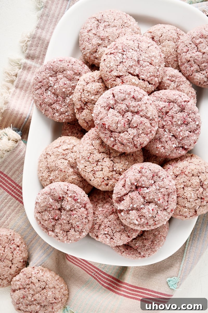 Overhead view of raspberry sugar cookies on a white tray, showcasing their perfect round shape and sparkling sanding sugar.