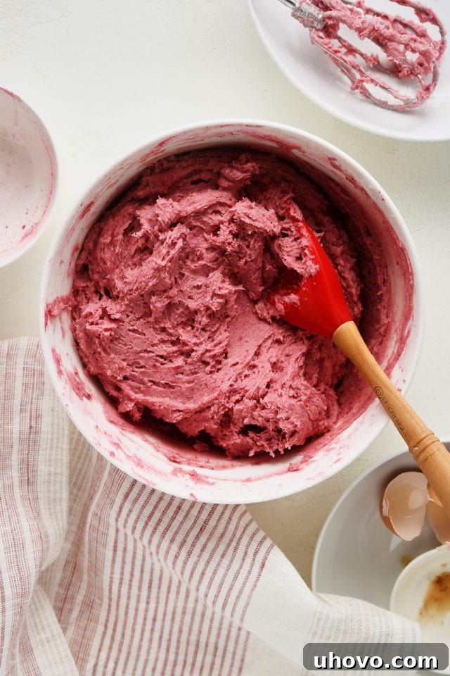 Overhead view of perfectly mixed raspberry sugar cookie dough in a white mixing bowl, ready for chilling.
