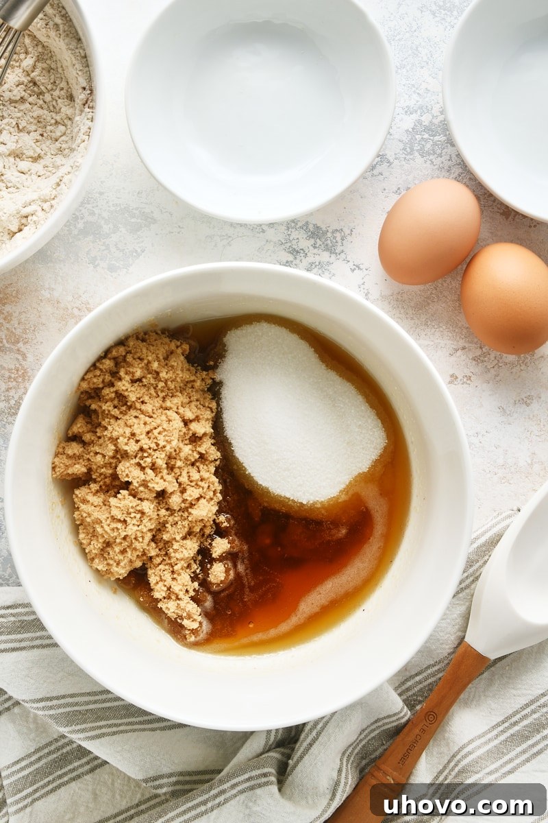 overhead view of brown butter, brown sugar, and granulated sugar in a white mixing bowl