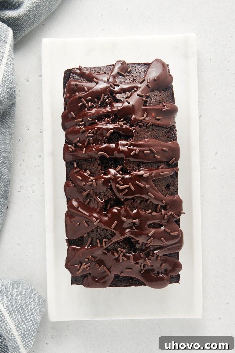 A glorious overhead view of the finished Chocolate Loaf Cake, lavishly covered with chocolate glaze and sprinkled with extra chocolate, ready to be enjoyed.