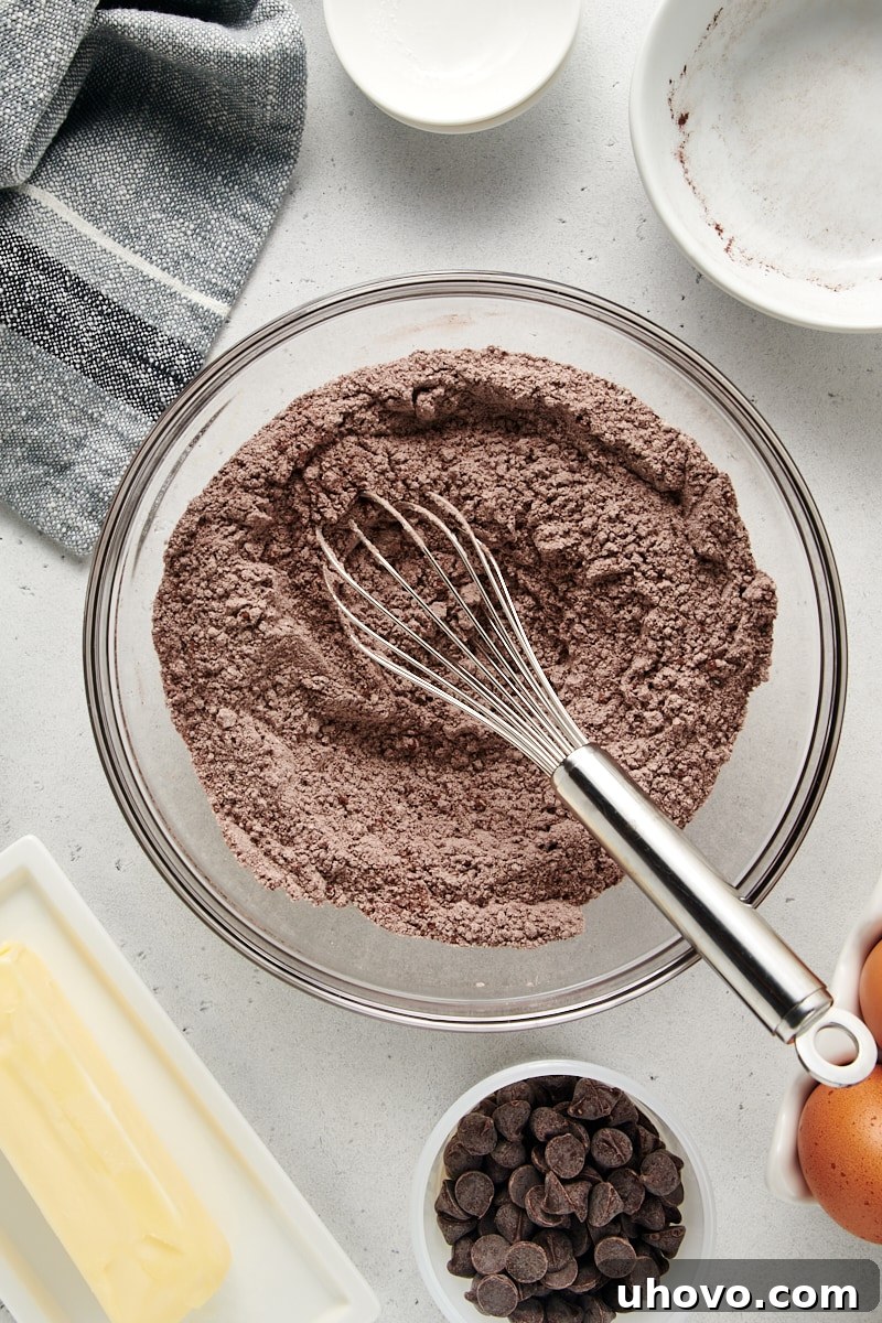 A perfectly blended mixture of dry ingredients for Chocolate Loaf Cake, showcasing a rich cocoa color in a glass bowl, prepared for the next step.