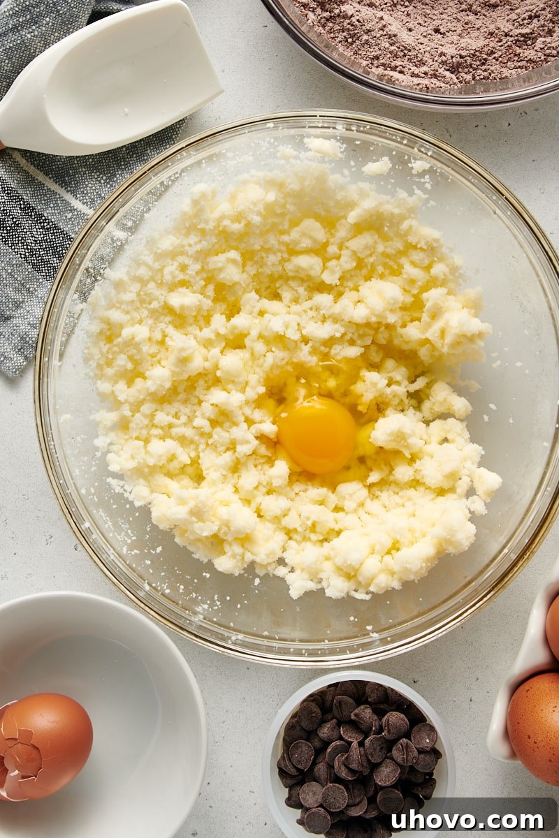 A close-up, overhead shot revealing the partially mixed wet ingredients for the Chocolate Loaf Cake, showing a smooth, creamy texture in a glass mixing bowl.