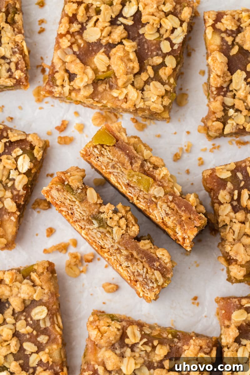 Overhead view of caramel apple bars on parchment paper with two bars sideways to show layers