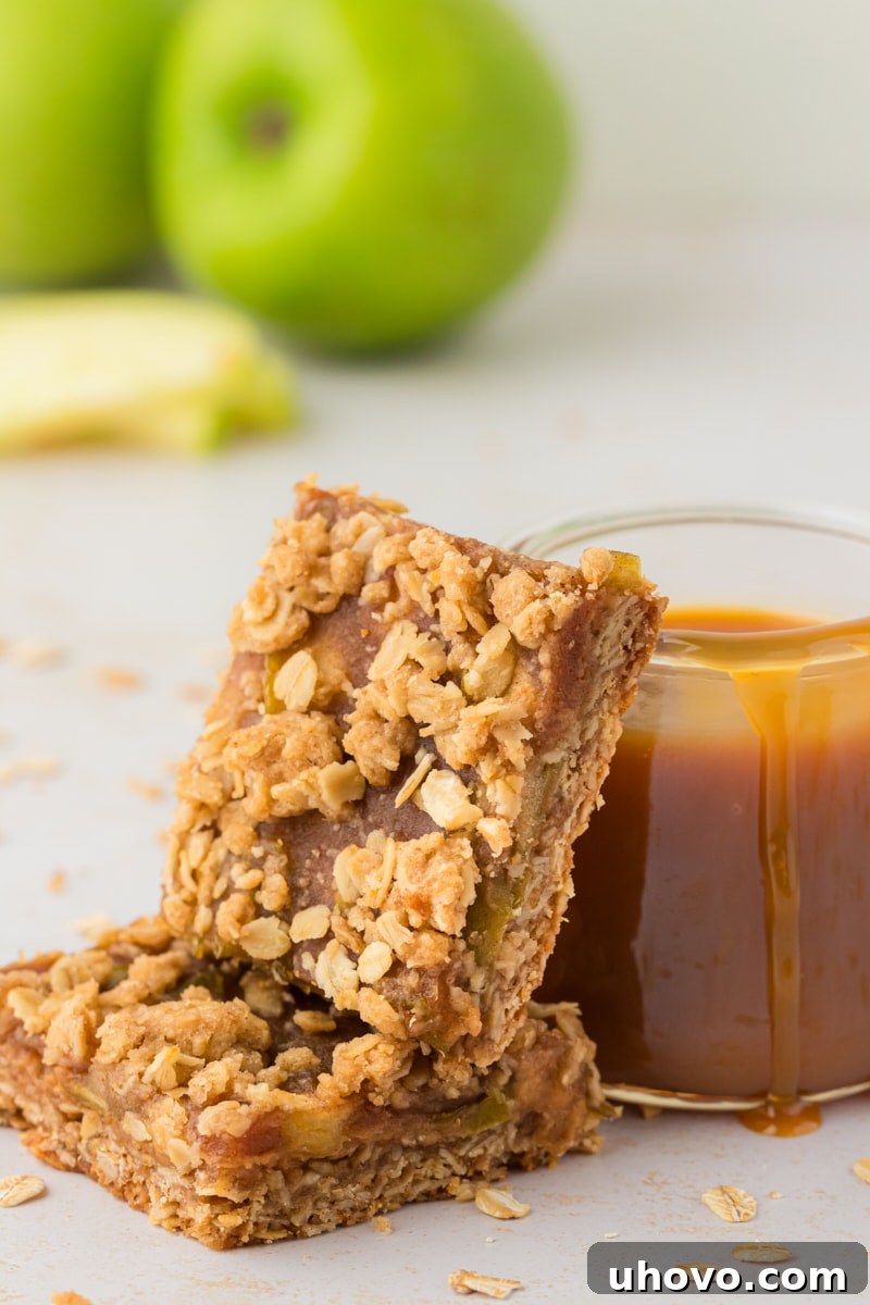 Stack of 2 caramel apple bars leaning against jar of caramel