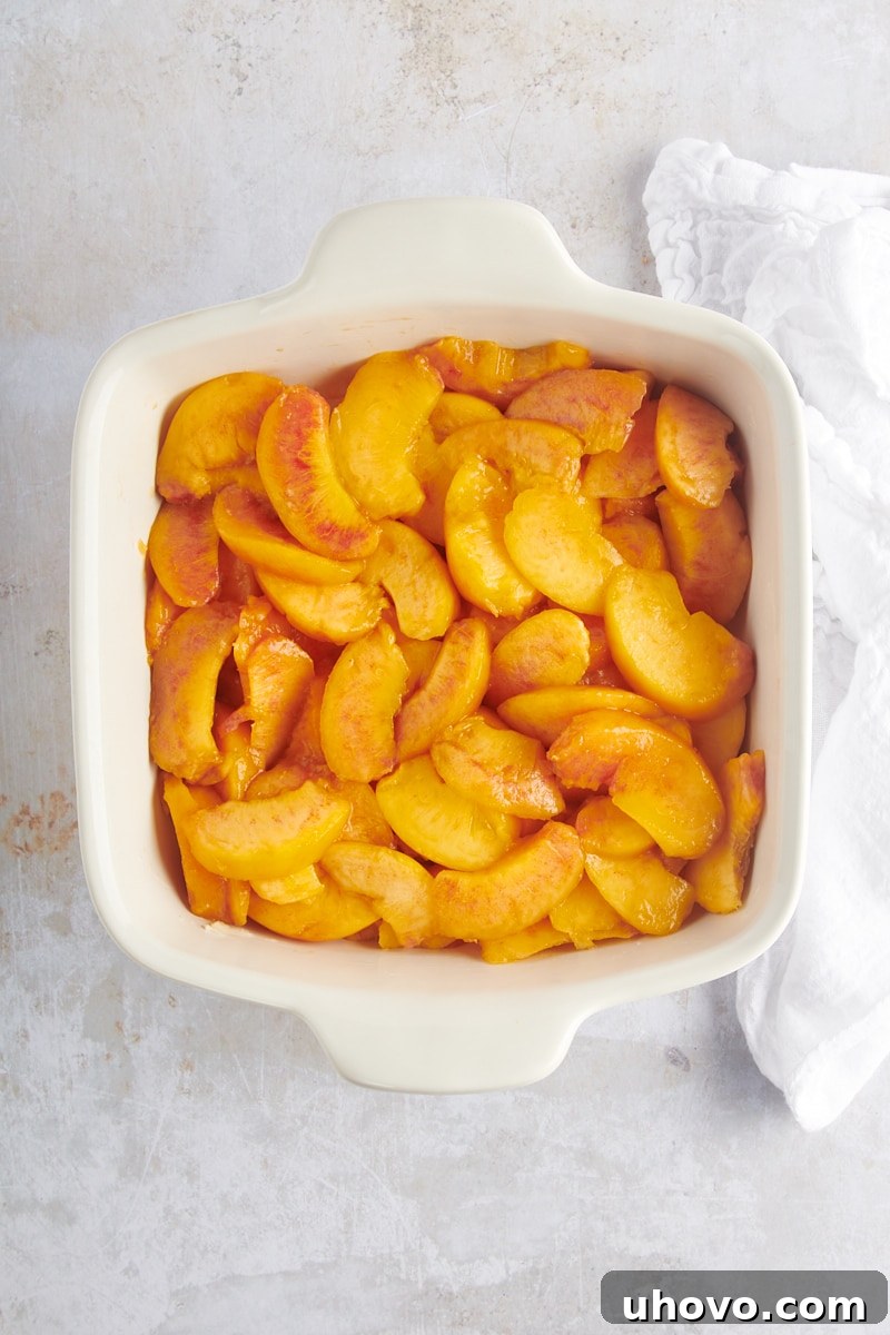 sliced peaches in a white baking dish