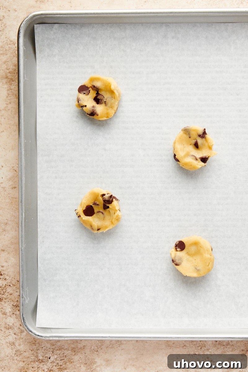 Overhead view of small, uniform portions of cookie dough on a surface, ready for the filling step.