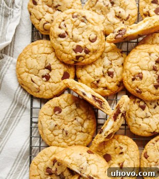 overhead view of Cheesecake-Stuffed Chocolate Chip Cookies piled on a wire rack
