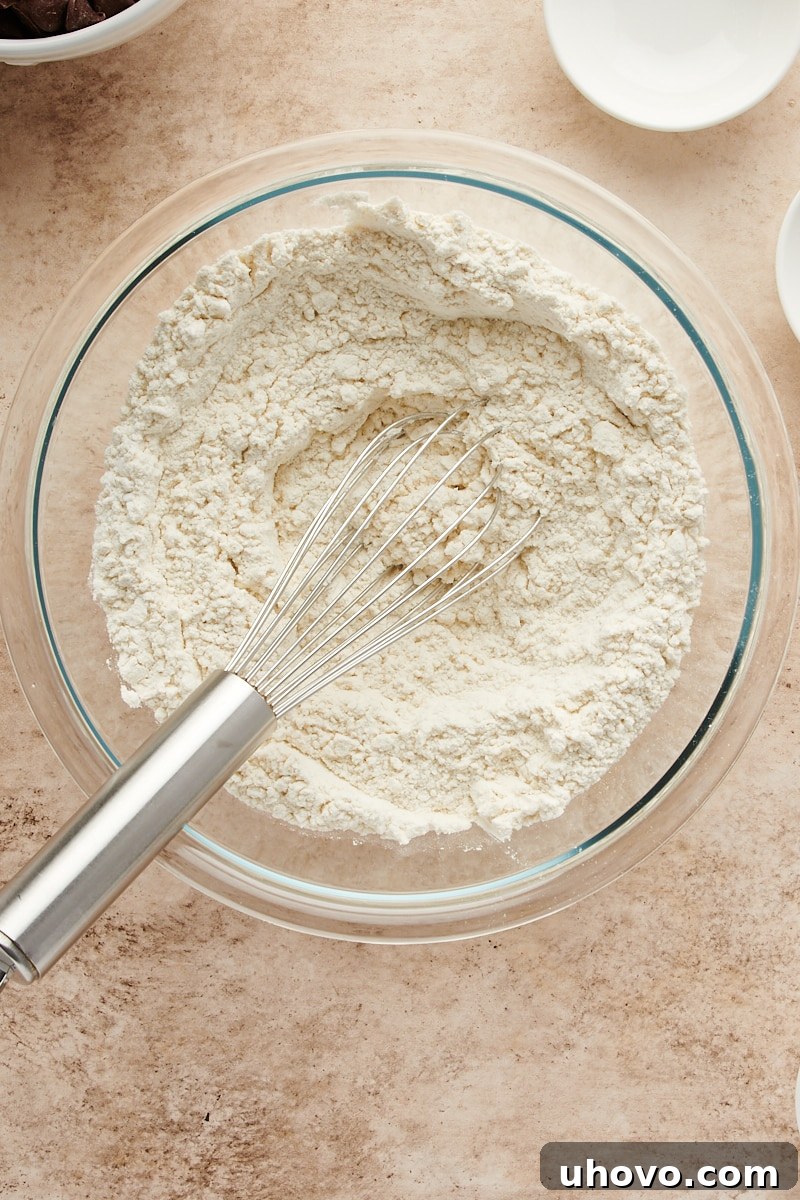 Overhead view of the dry ingredients after being whisked together in a glass mixing bowl, showing a uniform blend.