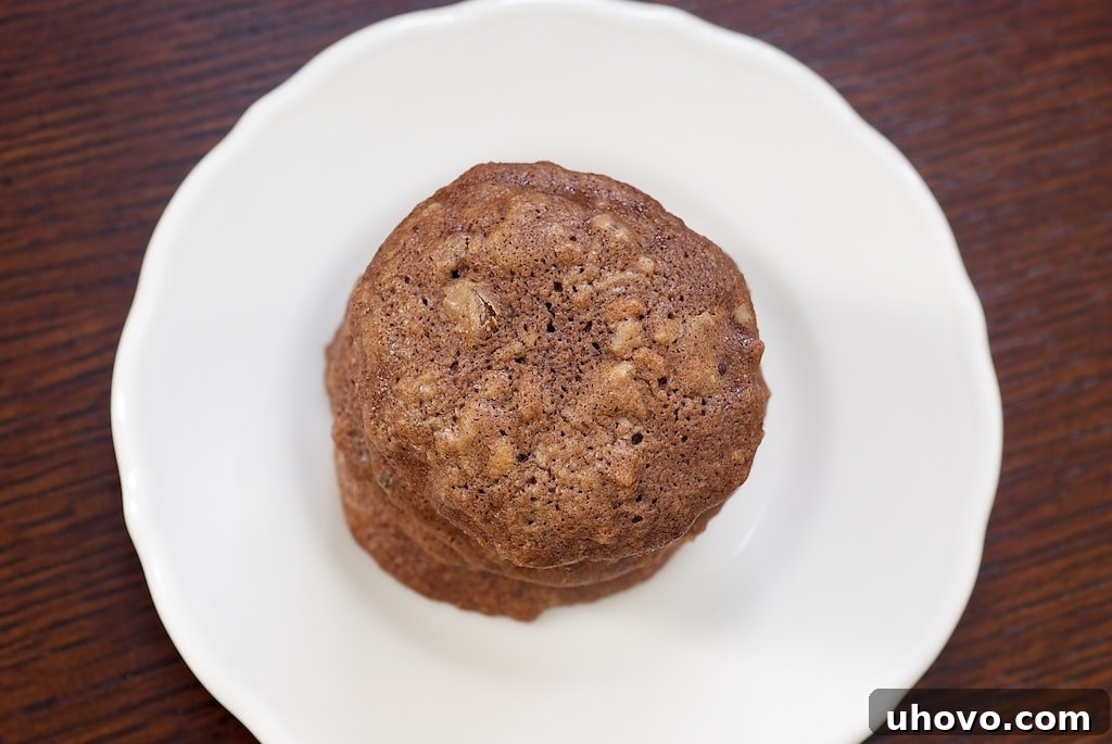 Rich, fudgy Chocolate Pecan Brownie Cookies with a crinkled top and a sprinkle of chopped pecans on a cooling rack.