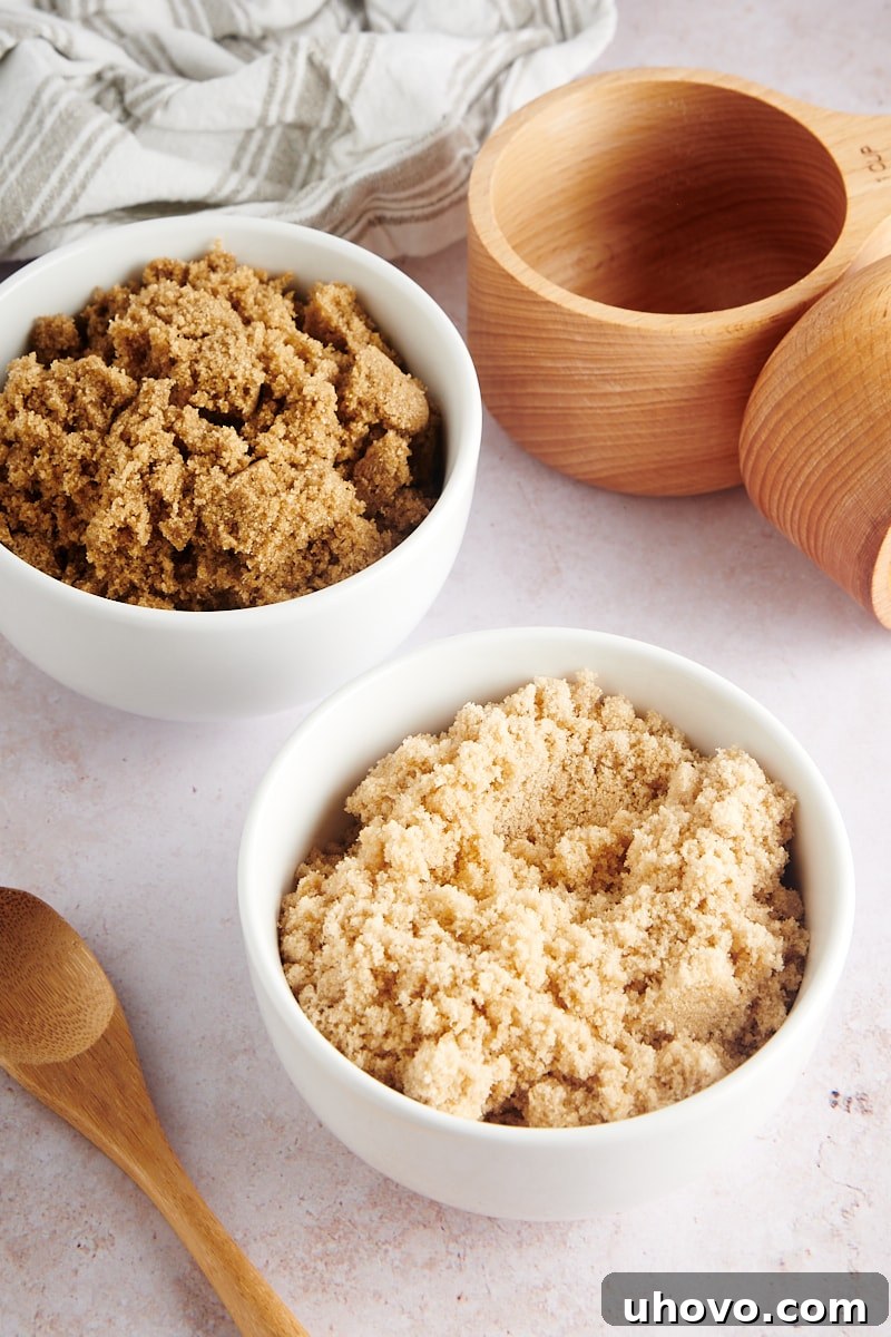 Two white bowls, one holding light brown sugar and the other dark brown sugar, displayed side-by-side.