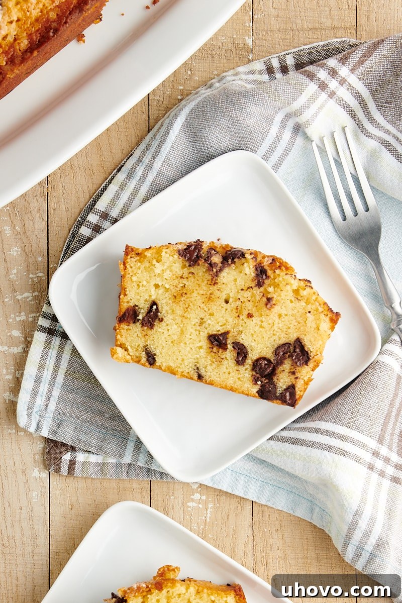 Overhead view of a single slice of Chocolate Chip Loaf Cake neatly placed on a square white plate, showing the rich chocolate chips