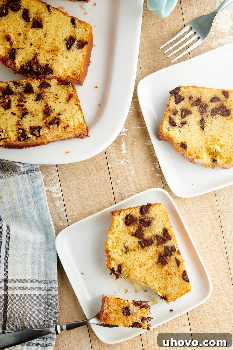 Slices of Chocolate Chip Loaf Cake artfully arranged on white plates and a matching serving tray, highlighting its inviting texture