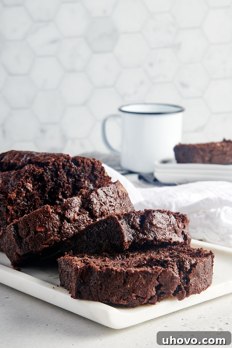 Slices of Chocolate Zucchini Bread arranged on a white tray, highlighting the rich texture.