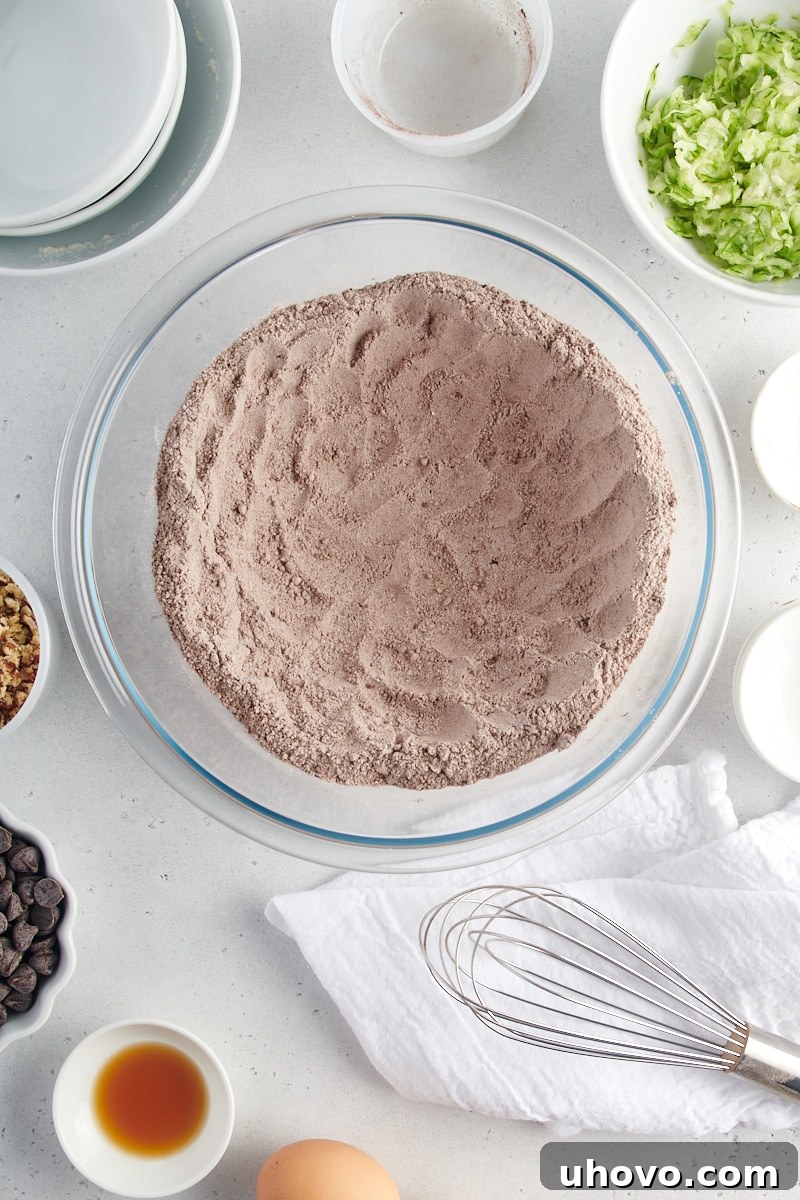 An overhead view of the mixed dry ingredients for Chocolate Zucchini Bread, showing a uniform blend of flour, sugars, and cocoa.