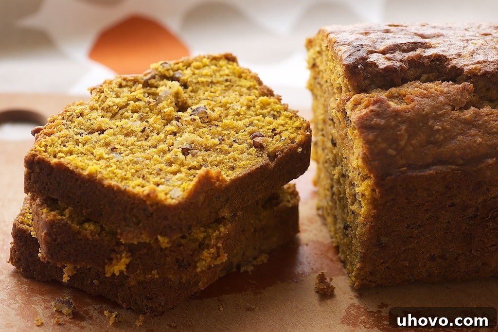 Stacked slices of homemade Pumpkin Pecan Bread, showcasing its moist texture and crunchy pecan bits, perfect for a fall breakfast or snack.
