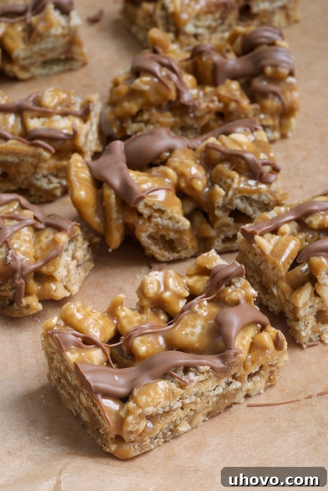 Perfectly sliced Good Morning Sunshine Bars, showcasing layers of peanut butter, cereal, and chocolate on parchment paper, ready to be devoured.