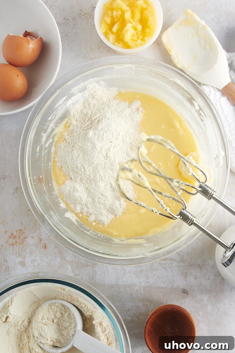 Overhead view of the dry flour mixture gradually being added to the wet cookie dough ingredients