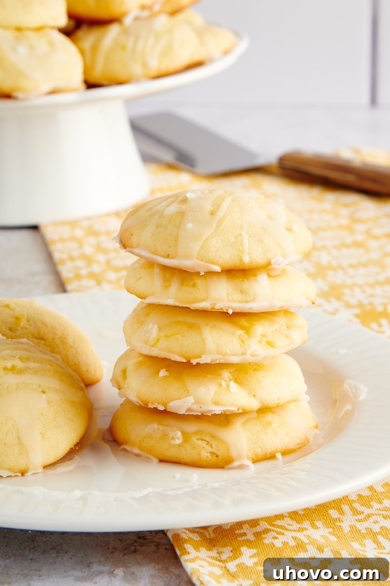 A perfectly stacked pile of Pineapple Cream Cheese Cookies on a clean white plate, highlighting their inviting texture
