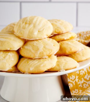 Pineapple Cream Cheese Cookies piled on a small white cake stand
