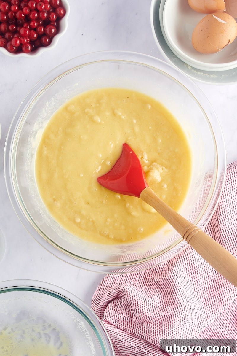 Overhead view of lightly mixed muffin batter in a glass mixing bowl