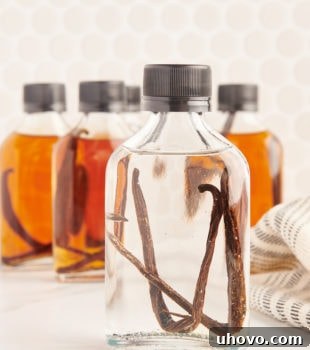 a freshly made bottle of vanilla extract in front of several bottles of aged vanilla extract