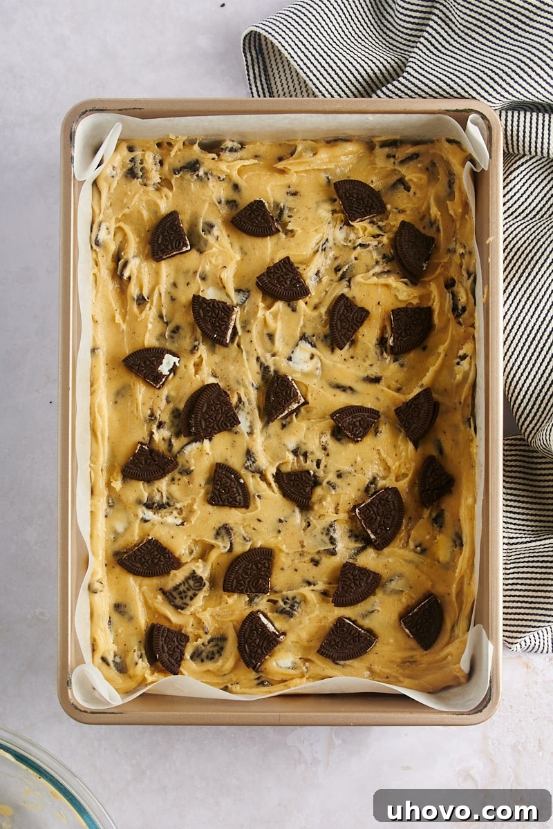 Overhead view of Cookies and Cream Blondies batter in the baking pan, perfectly spread and ready to go into the oven.