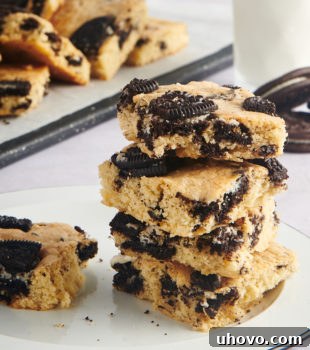 A stack of Cookies and Cream Blondies on a black-rimmed white plate.
